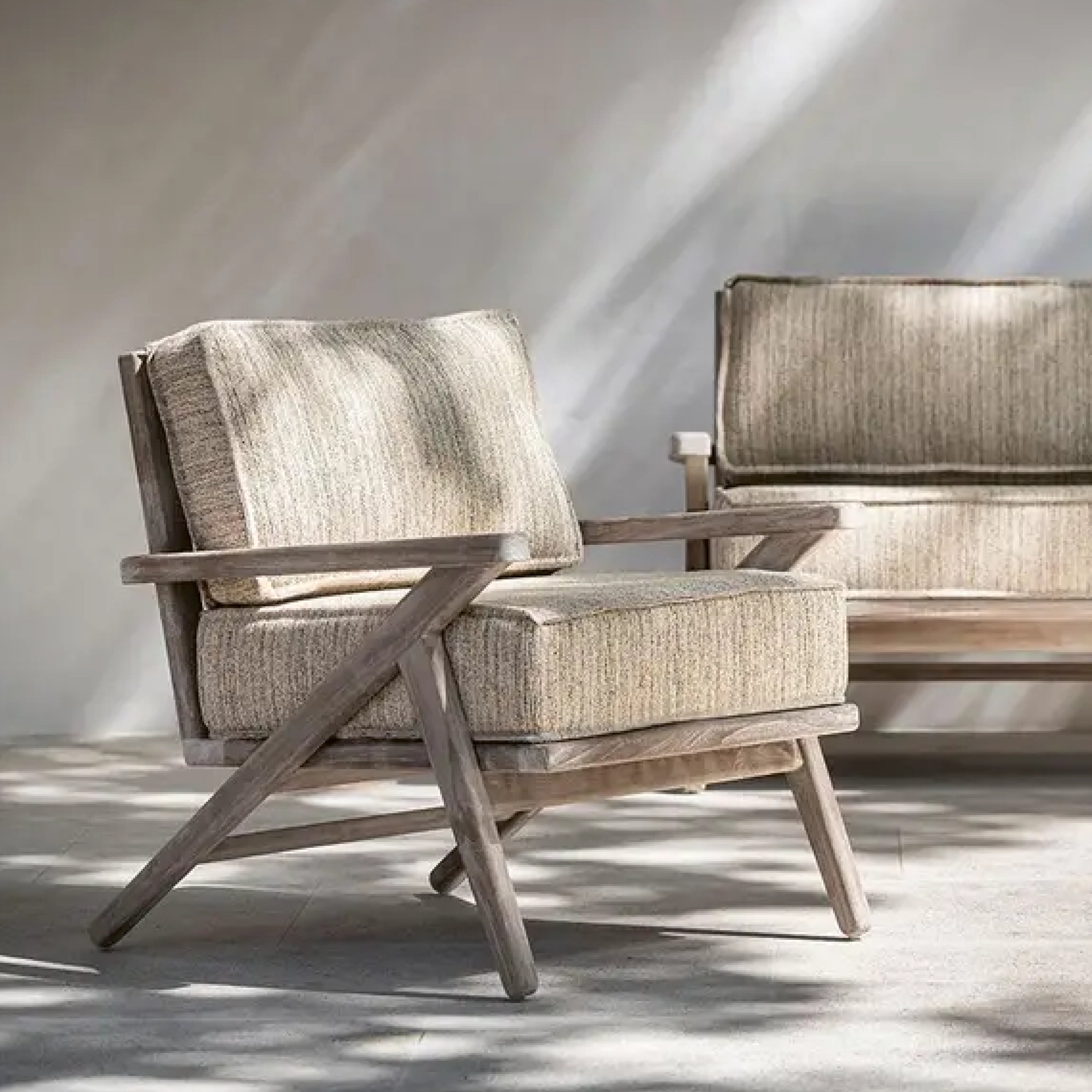 Outdoor-Loungesessel mit breiten Polstern in Naturtönen und Holzgestell – Gartensitzmöbel mit Retro-Charakter.