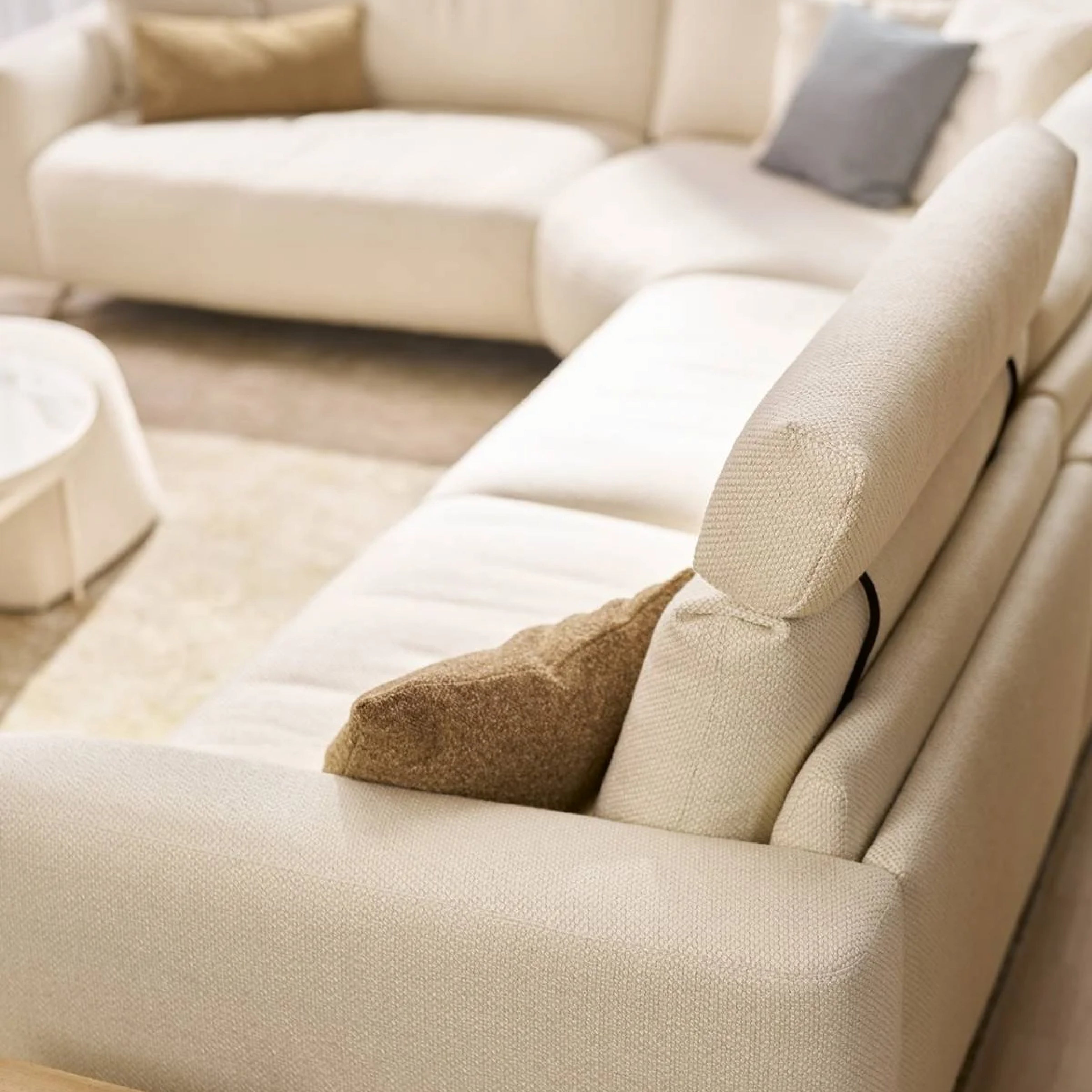 Helles Stoffsofa mit weicher Polsterung und Kissen in ruhiger, wohnlicher Atmosphäre