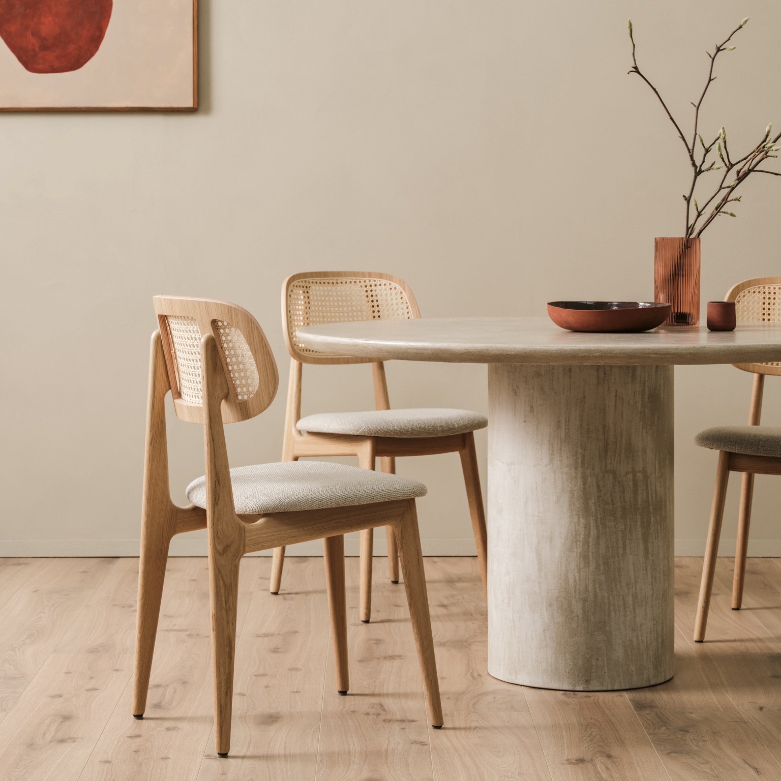 Esszimmer mit Vincent Sheppard Stühlen aus Lloyd Loom und rundem Holztisch in natürlicher, heller Atmosphäre