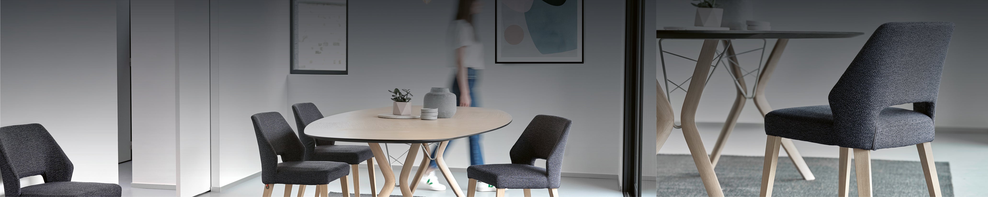 Designstuhl Lena von Mobitec mit markanter Rückenöffnung und gepolsterter Sitzfläche in dunklem Stoff – kombiniert mit hellem Holzgestell auf einem Teppich in modernem Wohnambiente.