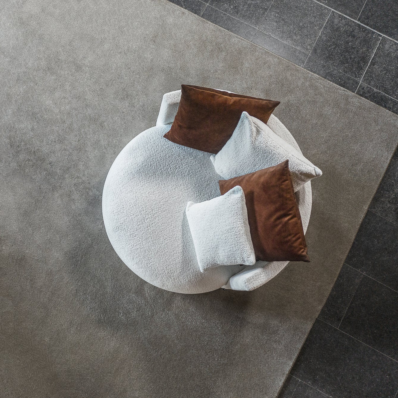 Sessel PASTILLE in weißem Doodle Stoff mit roten Kissen von oben fotografiert in einem modernen Wohnzimmer.