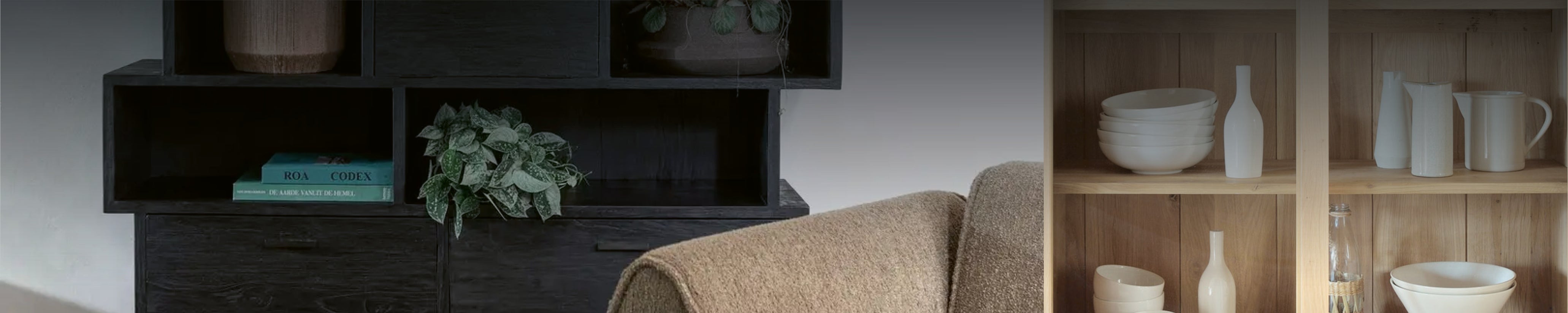 Wohnraum mit dunklem Regal und heller Massivholz-Vitrine mit offen präsentierter Keramik und Glas