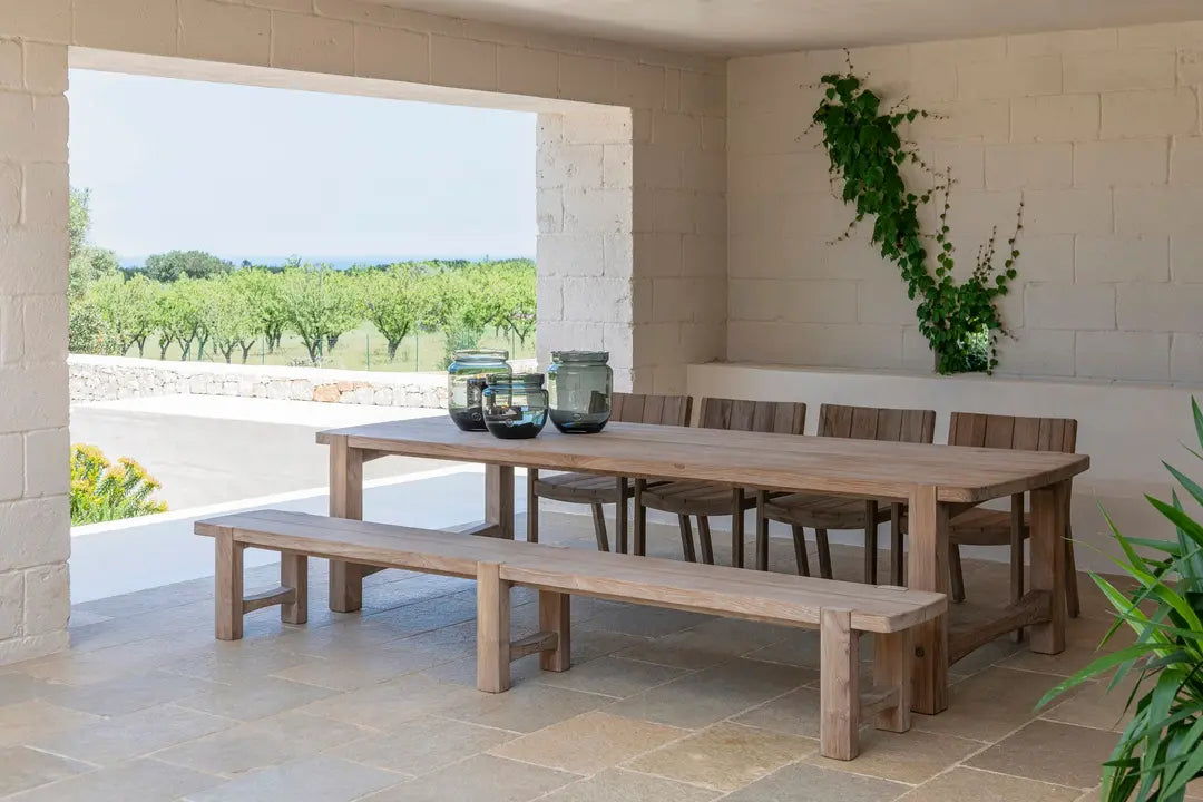 Gartentisch JACOBA von Gommaire stilvoll arrangiert auf einer Terrasse – kombiniert mit Outdoor-Stühlen, Naturaccessoires und Teakholz-Dekor, ideal für moderne Gartengestaltung und gesellige Sommerabende