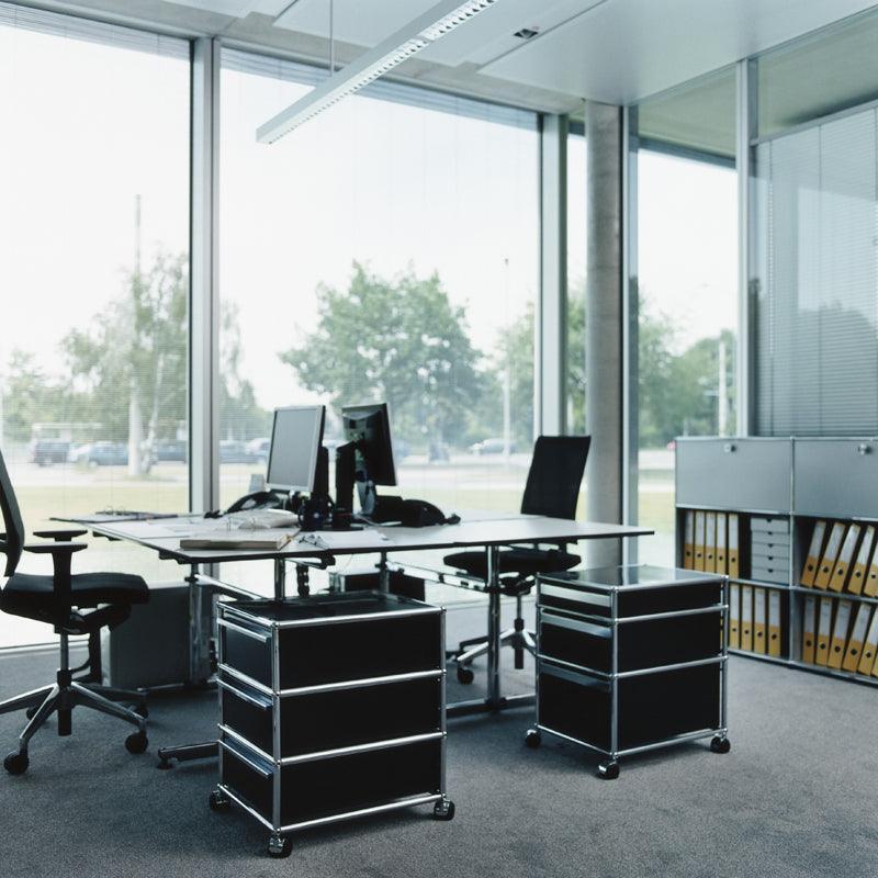 Rollcontainer M26 von USM Haller in edlem Graphitschwarz – elegante Büroeinrichtung mit stilvoller Stauraumlösung für strukturierte Arbeitsplätze im Designbüro oder Managementbereich