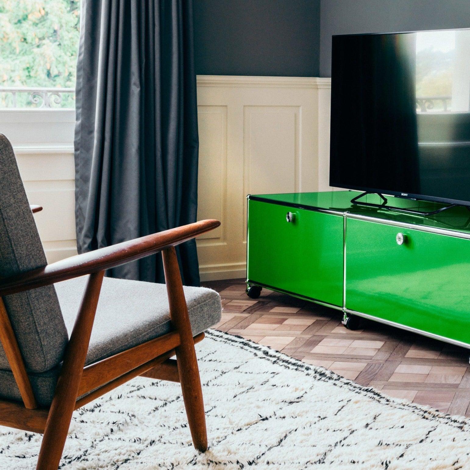 USM Haller Lowboard M61 in USM Grün – moderne Beispieleinrichtung im Wohnbereich mit ikonischem Design, modularem Aufbau und großzügigem Stauraum für Technik, Bücher oder Deko