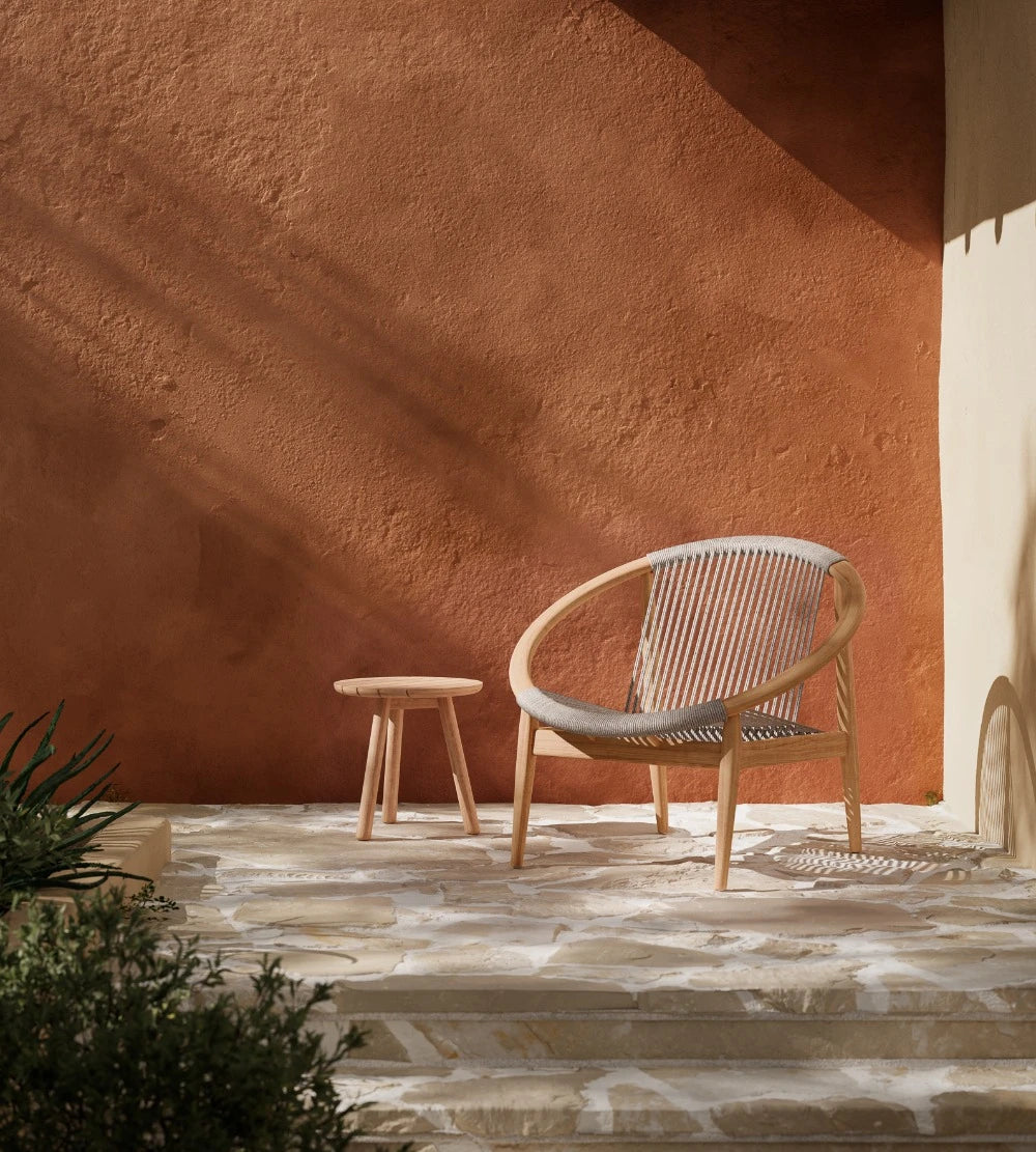 Vincent Sheppard FRIDA Gartensessel mit offener Silhouette im Outdoor-Loungebereich in der Farbe Dune White.