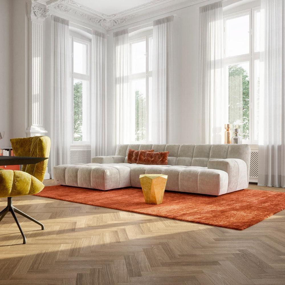 Sofa-Daybed OCEAN 7 von Bretz in weißem Eisbär-Stoff, gemütlich integriert in ein Boho-inspiriertes Wohnambiente mit Teppich, Pflanzen und warmen Naturmaterialien