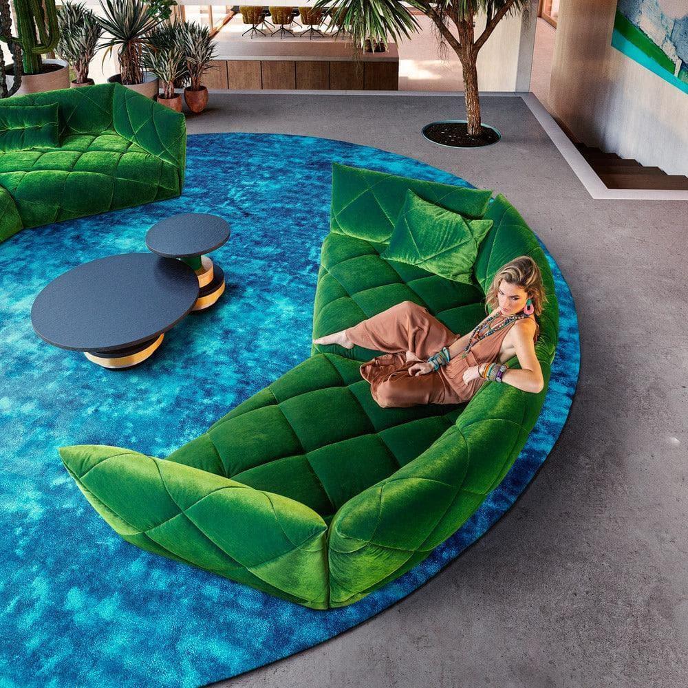 Designsofa TERATAI G106 von Bretz in Rain Forest, stilvoll platziert in einem modernen Wohnzimmer mit Holzfußboden, Teppich und sanfter Beleuchtung