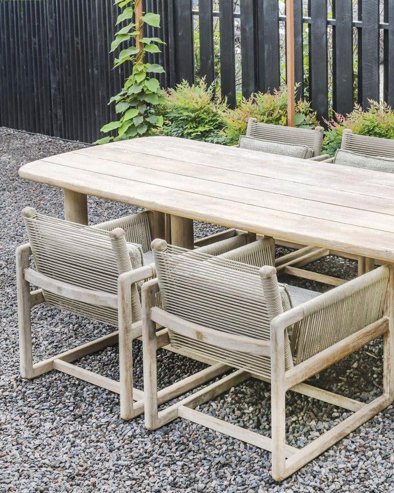 Esstisch CARLO im Garten unter Sonnenschirm – großzügiger Teakholz-Tisch von Gommaire als Herzstück einer Outdoor-Essgruppe im Grünen