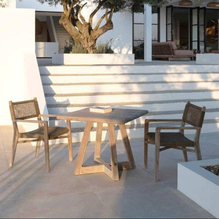 Bistrotisch DENNIS von Gommaire auf Terrasse – eleganter Teaktisch für zwei Personen, kombiniert mit Gartenstühlen für stilvolle Frühstücksmomente im Freien