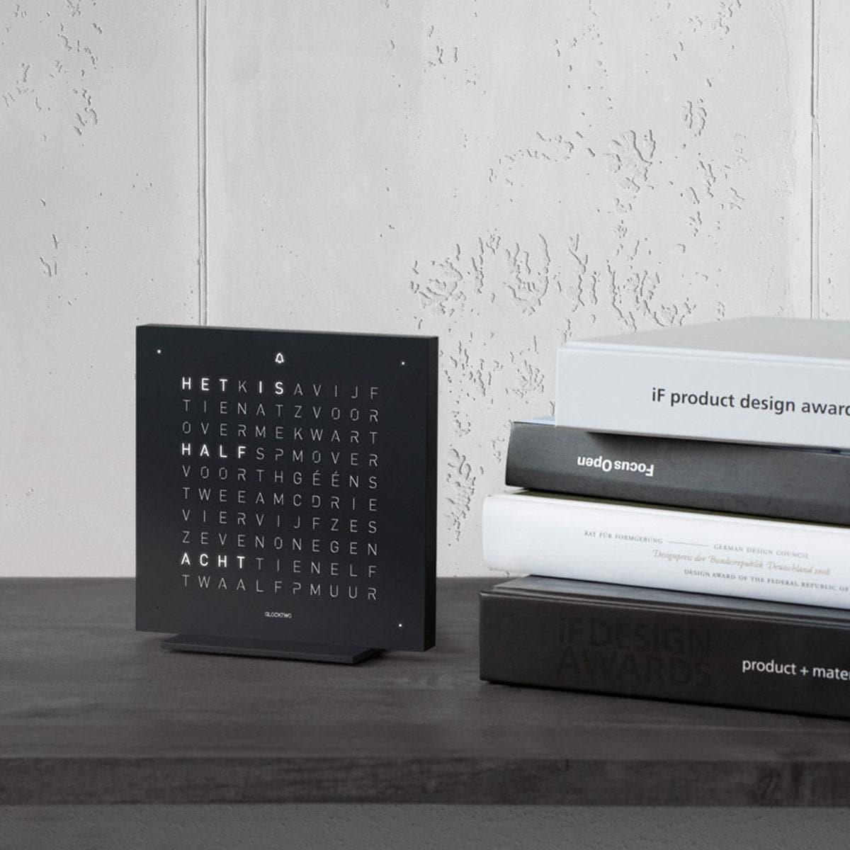 QLOCKTWO EARTH 13.5 Deep Black – matzwarte design tafelklok stijlvol gepresenteerd in een modern interieur met minimalistische uitstraling