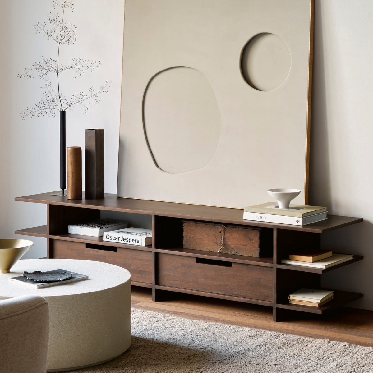 Modernes TV-Lowboard aus dunklem Holz mit offenen Fächern und Dekoration im Wohnzimmer