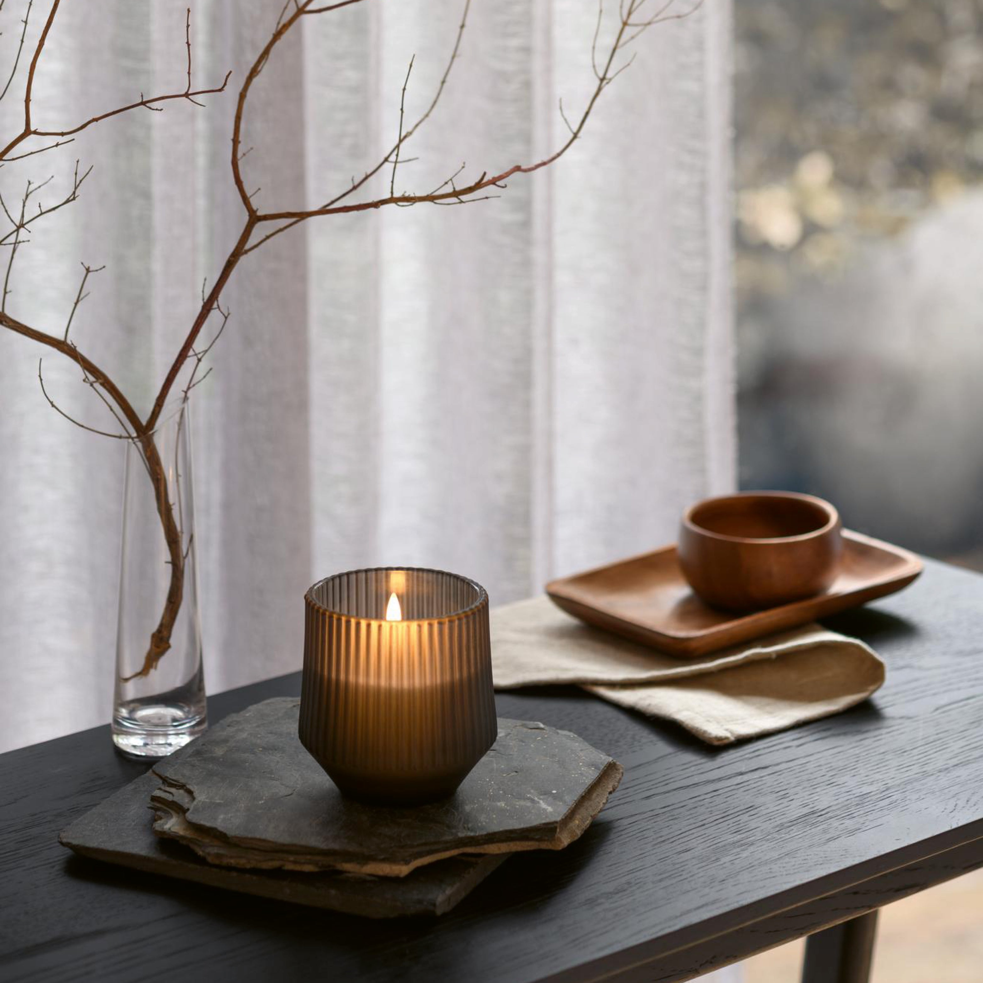 Stimmungsvolle LED-Kerzen mit Echtwachs in Glass und Timerfunktion in moderner Wohnumgebung.