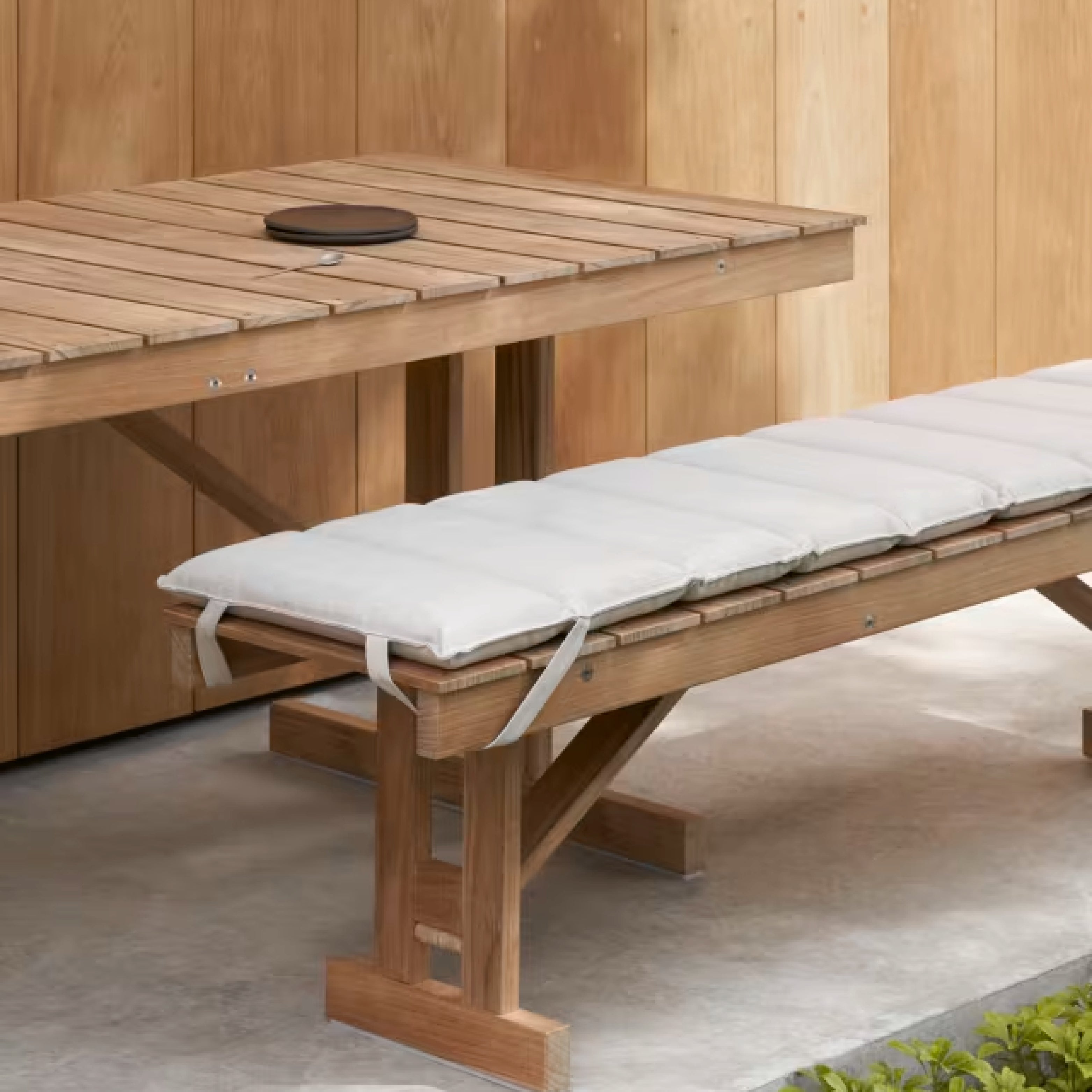 Gartenbank mit weißer Auflage und passender Teaktisch von Carl Hansen & Søn – Outdoor-Möbel im skandinavischen Stil.