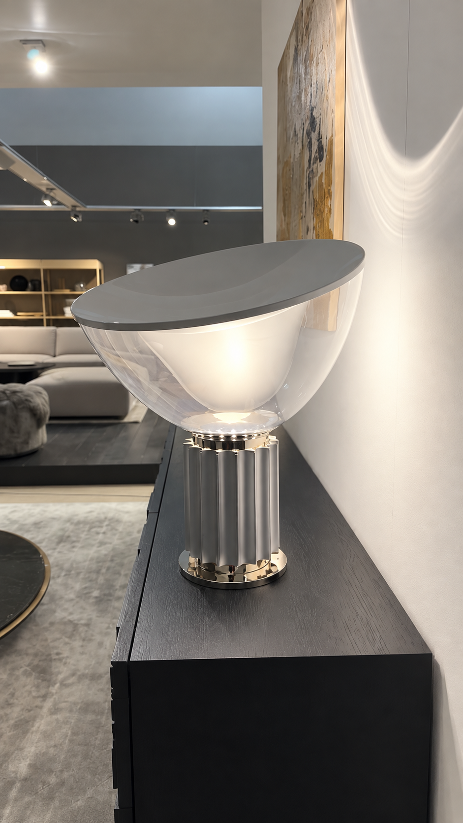 Flos TACCIA Tischlampe in Aluminium und Silber auf einem Sideboard
