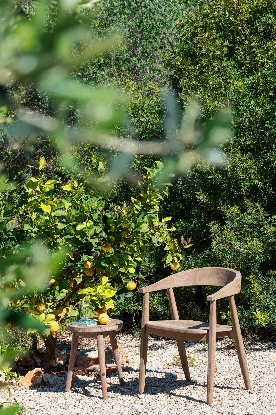 Teakhocker Asti von Gommaire in natürlicher Gartenszene – schlicht, robust und zeitlos als Sitz oder Beistelltisch