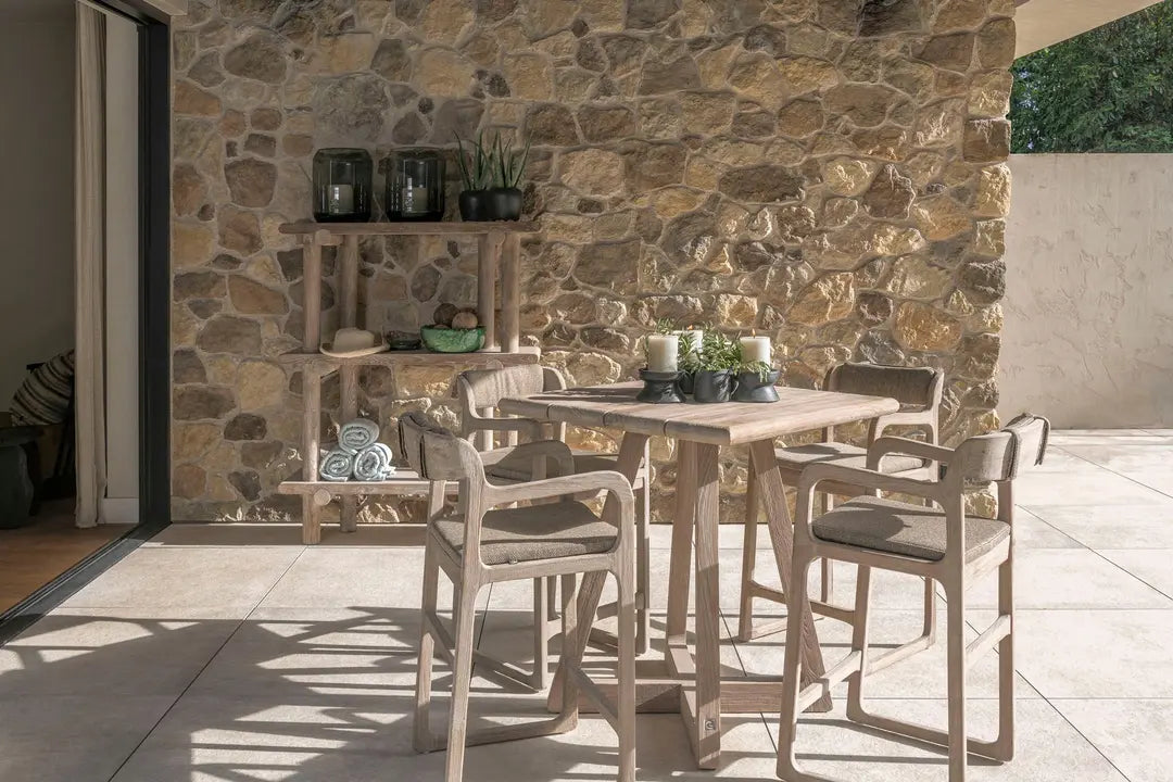 Gommaire Barstuhl SALLY im Outdoor-Lounge-Ambiente – kombiniert mit Stehtisch und grüner Bepflanzung für stilvolle Gartengestaltung mit Teakmöbeln