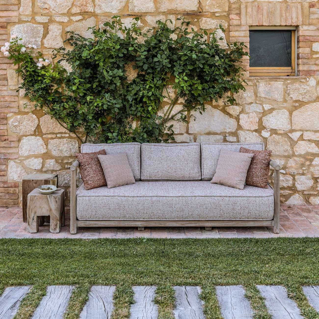 2,5-Sitzer MIEKE von Gommaire auf einer Terrasse, kombiniert mit Kissen und Beistelltisch – stilvolles Outdoor-Sofa im Organic Living Stil