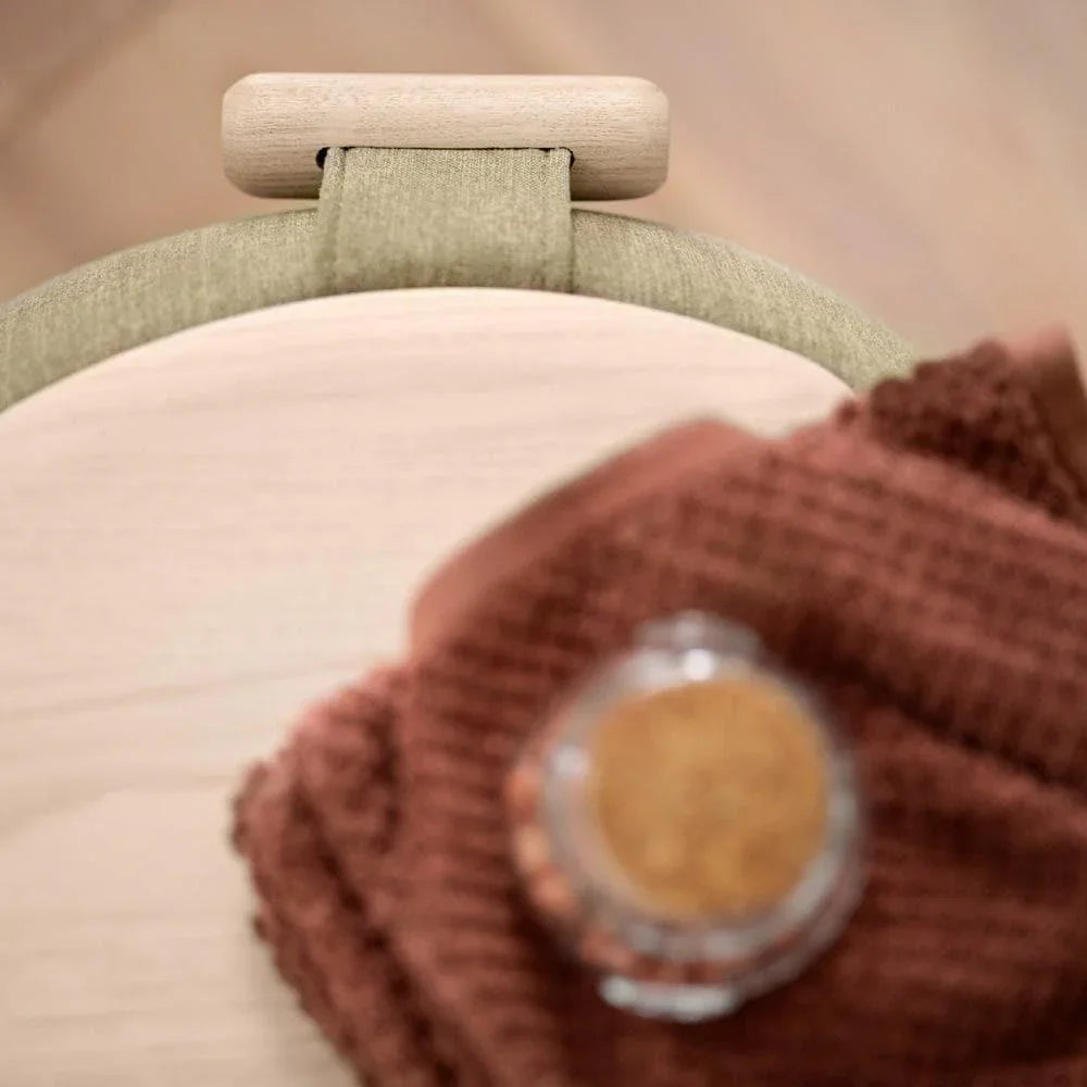 THALIA R0610 Pouf in einem hellen Lounge-Setting mit natürlichem Licht, Holzdetails und gemütlichem Ambiente