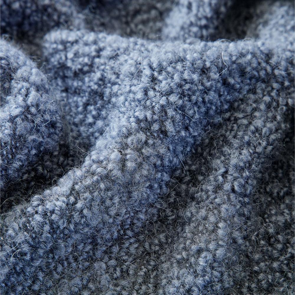 TUIS Kuscheldecke von Vetsak in Dunkelblau – stilvoll drapiert auf dem Sofa