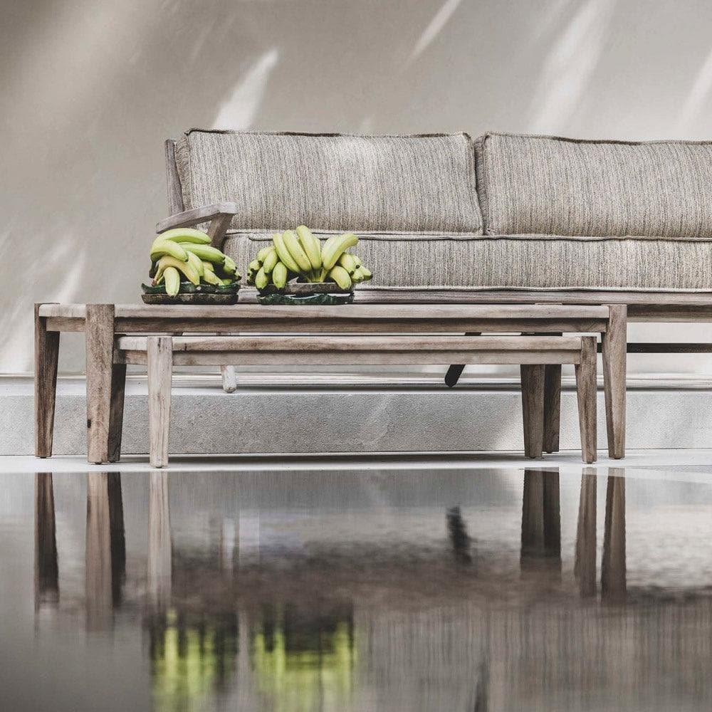 Couchtisch FLOOR von Gommaire in Kombination mit Lounge-Sofa – stilvolle Outdoor-Szene mit natürlichen Materialien und Teakmöbeln