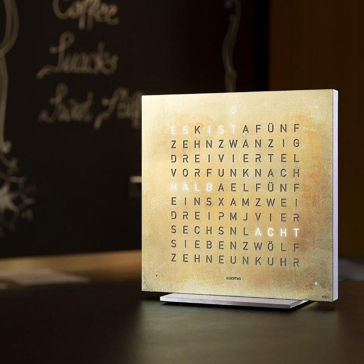 QLOCKTWO EARTH 13.5 Silver & Gold – exklusive Tischuhr der Creator’s Edition, elegant inszeniert in hochwertigem Wohnambiente