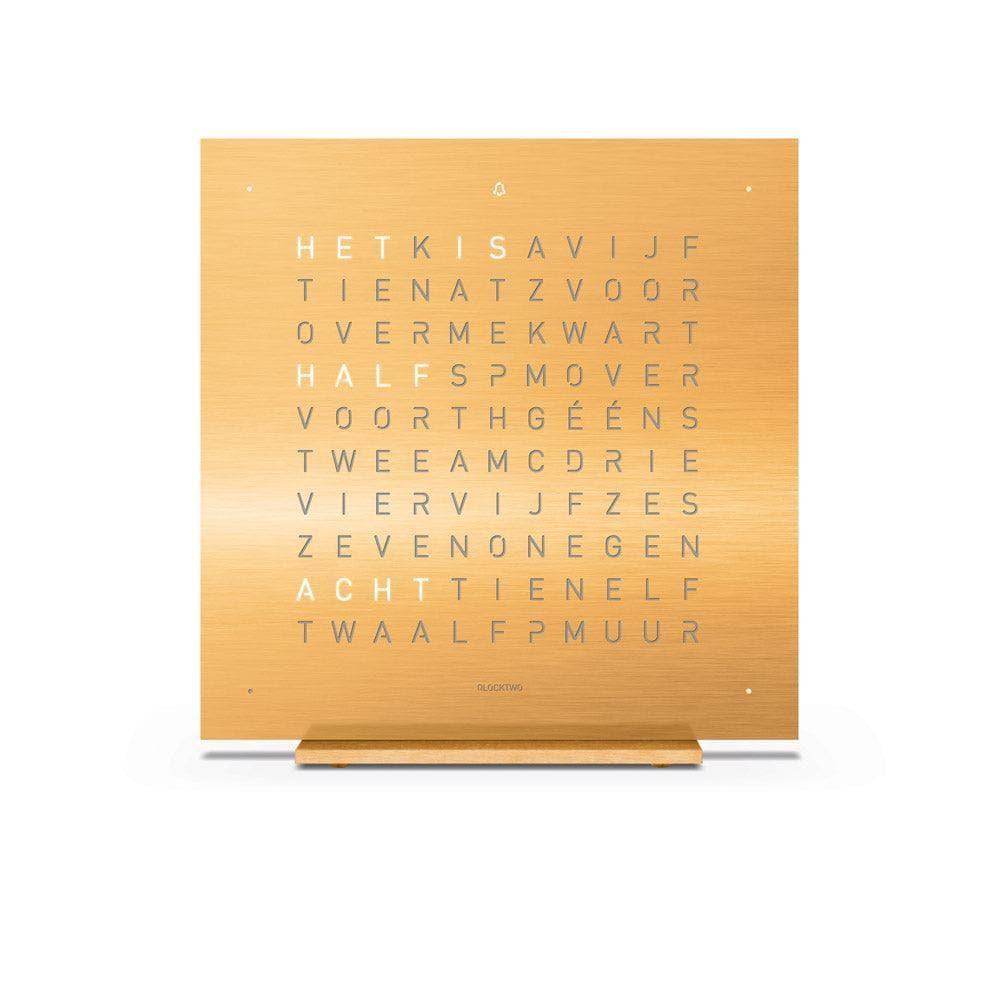 QLOCKTWO EARTH 13.5 Golden Legend – vooraanzicht van de luxe tafelklok in goudkleurig staal met typografische tijdsaanduiding